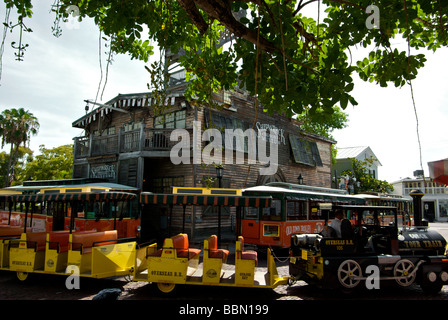 Conch Train and Old Town Trolley guided city tours transportation in Mallory Square in front of Shipwreck Treasures Museum Stock Photo