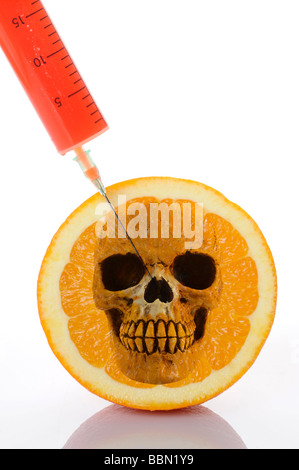 Syringe in orange, symbolic image for genetically modified foods Stock Photo