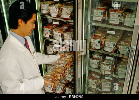 Technician pulling supply from refrigerated blood bank storage Stock Photo