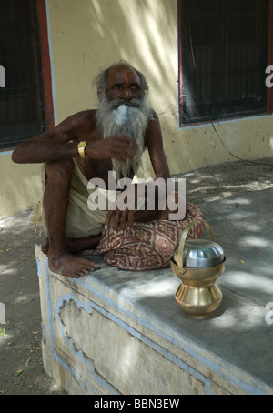 a old white bearded Indian man sits along Stock Photo