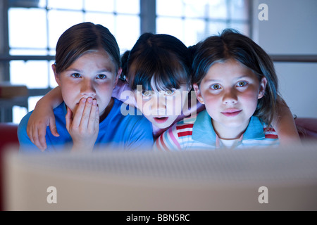 Three girls looking anxiously at a screen Stock Photo