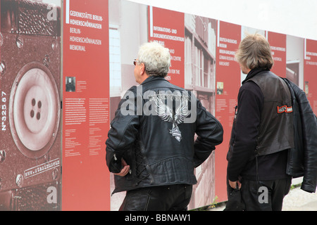 Two man with Harley Davidson jackets looking at the pictures of the exhibition at Check Point Charlie Berlin Germany Europe Stock Photo
