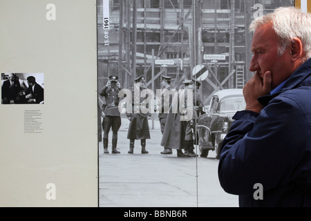Man looking at the old picture of the soldiers at the exhibition of the Check Point Charlie Berlin Germany Europe Stock Photo