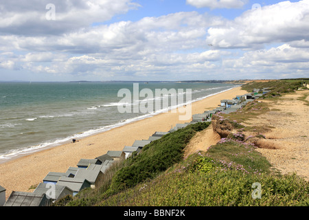 Beach huts line the coast at Milford on Sea in Hampshire Stock Photo