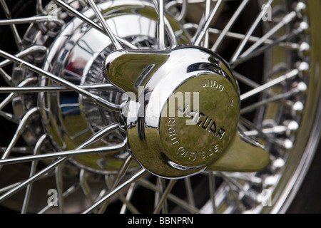 Motoring chromed wheel spinner on wire wheel of classic 1950s Jaguar XK140 sports car Stock Photo