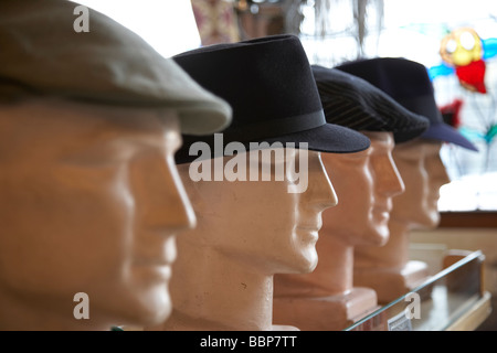 Hats on display on models in a shop Stock Photo