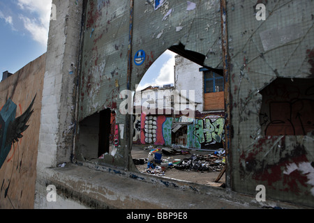 A smashed window glass in the heart of Brick Lane reveals some vivid graffiti. Stock Photo