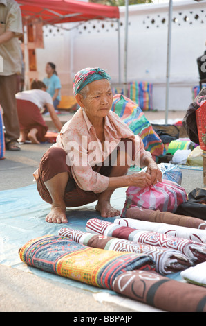 An old Lao woman setting up her ethnic souvenir stall in Luang Prabang Laos Stock Photo
