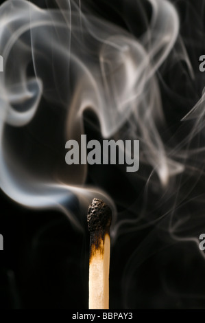 A  close up of smoking Match on a black background Stock Photo