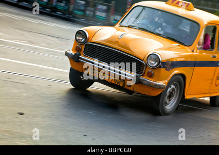 Yellow taxi transporting passengers, Kolkata, India Stock Photo