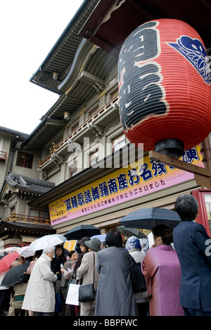 Rainy weather does not dampen the spirits of people waiting in line for kabuki tickets at the Minamiza Theater in Kyoto Stock Photo