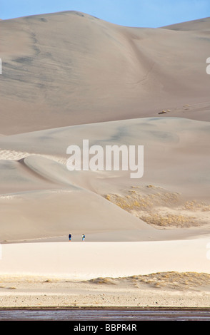 Colorado San Luis Valley Great Sand Dunes National Park Preserve couple across Medano Creek hiking on dunes Stock Photo