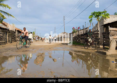 Road with water filled potholes provide breeding grounds for Malaria mosquitoes Quelimane Mozambique Stock Photo