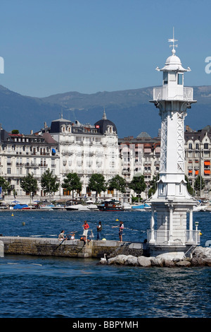 BATHING AND RELAXING IN FRONT OF THE WHITE LIGHTHOUSE OF THE BAINS DES PAQUIS IN THE GENEVA HARBOUR ON LAKE GENEVA, SWITZERLAND Stock Photo