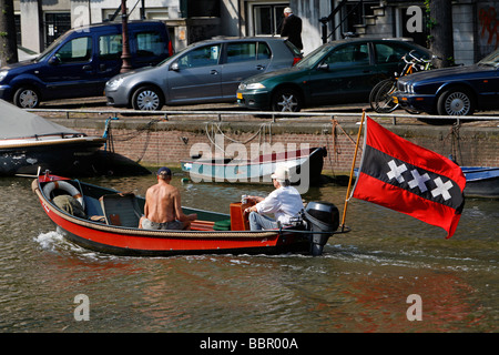 BOAT WITH THE FLAG WITH THREE CROSSES, EMBLEM OF THE CITY OF AMSTERDAM, AND CAFE WALEM KEIZERSGRACHT, NETHERLANDS, HOLLAND Stock Photo