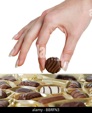 Woman Selecting a Truffle from a Box of Chocolates Stock Photo