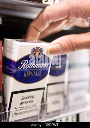 Packets of Rothmans cigarettes made by British American Tobacco sit on the shelf of a retail store Stock Photo