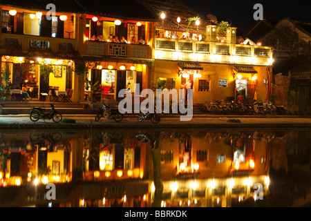 'Hoi An' riverside restaurants at night, colonial building lights reflected in water of 'Thu Bon' River, Vietnam Stock Photo