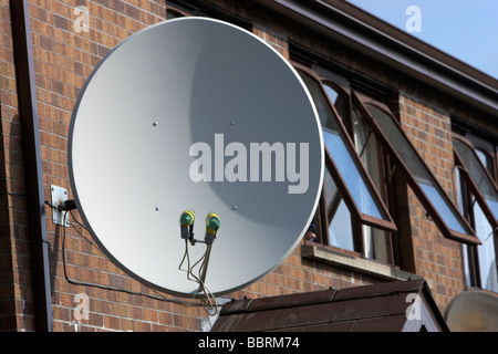 large satellite dish attached to the outside of a row of houses in the uk Stock Photo