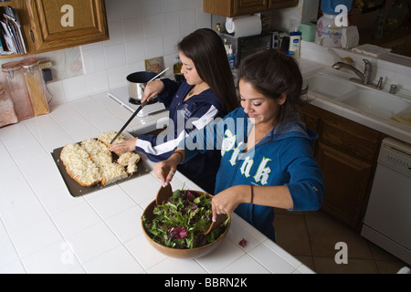 Two Young women from El Salvador. Two Hispanic sisters cooking in kitchen diverse MR  © Myrleen Pearson Stock Photo