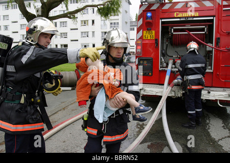 FIREFIGHTERS RESCUING A CHILD FROM AN APARTMENT FIRE IN A SUBSIDIZED HOUSING BUILDING, LAVAL, MAYENNE (53), FRANCE Stock Photo