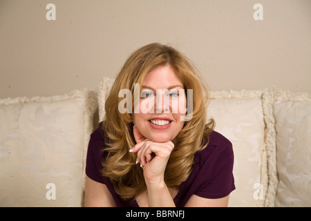 Portrait of mature woman sitting on couch with chin on hand. MR  © Myrleen Pearson Stock Photo