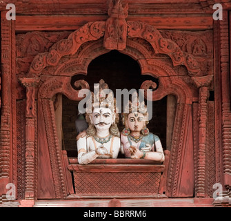 Kathmandu.  Shiva and his Consort Parvati.  Wooden representations look upon Durbar Square from window in Shiva Parvati Temple. Stock Photo