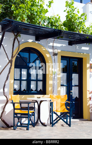 cafe taverna and hotel setting with table and chairs and grape vines in the greek islands Stock Photo