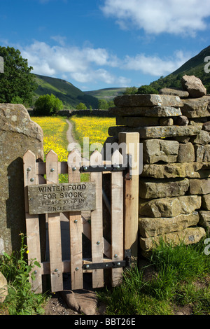 Sign on a gate leading to a hay meadow, near Muker, Swaledale, North Yorkshire 'Winter Food For Stock' Stock Photo