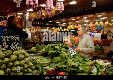 Customers buying vegetables in La Boqueria market in Barcelona Spain Stock Photo