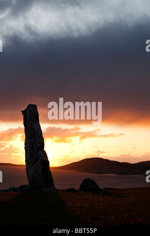 Mcleods standing stone sunset silhouette, looking over sound of Taransay, Isle of Harris, Outer Hebrides, Scotland Stock Photo
