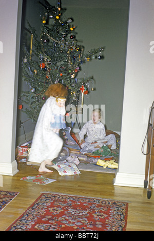 Girls open presents Christmas morning 1957 Stock Photo