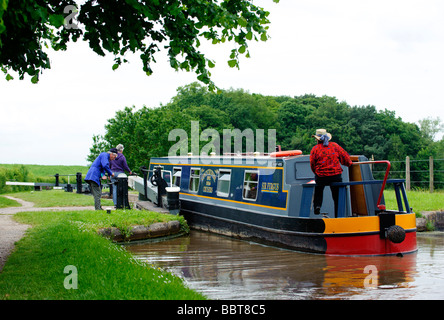 The crew of a barge negotiate one of the gates at Tyrley Locks on the Shropshire Union Canal Stock Photo