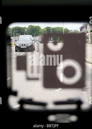 A view through the window of a Safety Camera van showing the operator's view with the window closed and speed camera symbol Stock Photo