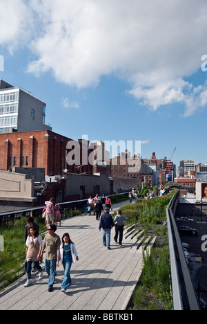 pedestrians strolling on the walkway of the elevated High Line park on a magnificent spring Sunday, in Manhattan, New York City Stock Photo