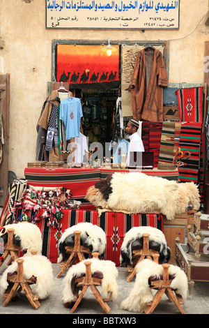 A shop in Souq Waqif in Doha Qatar selling stools fashioned as camel saddles traditional textiles and other Arab goods Stock Photo