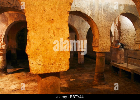 Tourist visiting Moorish aljibe water cistern in Palacio de las Veletas Caceres Extremadura Spain Europe Stock Photo