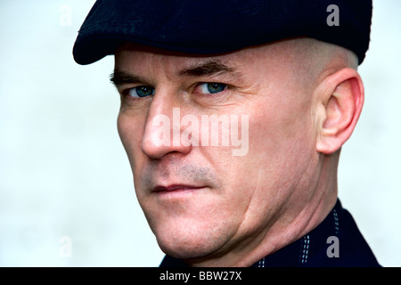 Bald man in his late 40's wearing a dark suit and cap. Stock Photo