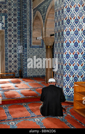 Muslim man praying in the Ruestem Pasa Mosque, wall decorations with Iznik tiles, Eminoenue, Istanbul, Turkey Stock Photo