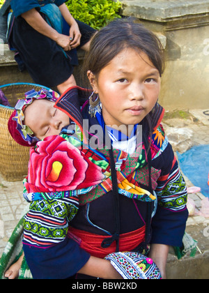 Young Hmong girl carrying baby on her back, Sapa, Vietnam JPH0205 Stock Photo
