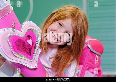Girl on her first day at school holding a schultuete, school cone filled with sweets and gifts Stock Photo