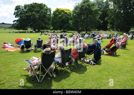 Crowd audience with picnic on a lawn in West Country England in the summer sun Stock Photo