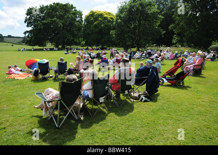 Crowd audience with picnic on a lawn in West Country England in the summer sun Stock Photo