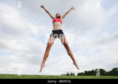 Young Woman jumping in the air Stock Photo