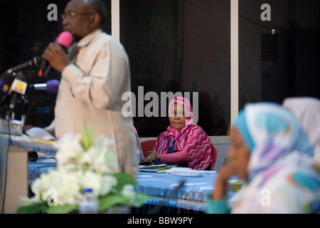 A lady official listens to a speech by the Governor of North Darfur, Osman Mohammed Yousef Kibir during womens' conference Stock Photo
