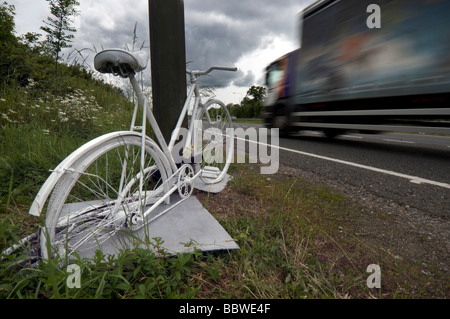 A Ghost Bike - a white painted cycle chained to the spot where a cyclist was killed in a road accident on the A23. Stock Photo