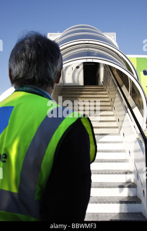 Man for an airport staff on the runway between commercial airplanes ...