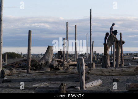 People standing on wooden posts along shoreline at Vancouver, British Columbia, Canada Stock Photo