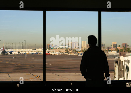a man looks through the window in the waiting area of the Phoenix airport Stock Photo