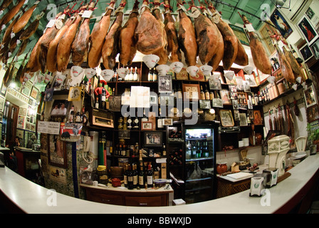 Serrano hams hanging from the ceiling in tapas bar in Sevilla Andalucia Spain Stock Photo